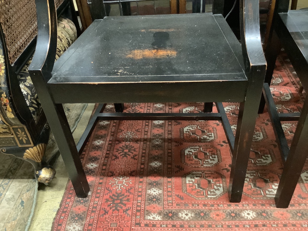 A pair of George III style ebonised elbow chairs